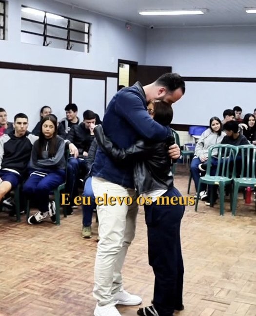 Lucas abraça um aluno durante a palestra